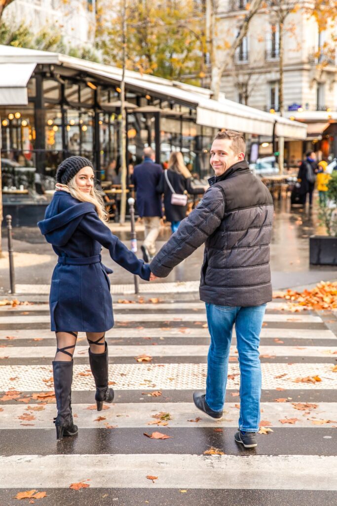 picture of the author and her husband in christmas clothes in paris in front of a cute cafe that makes paris worth visiting