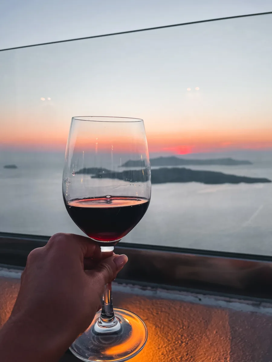 santorini sunset and volcano with wine glass