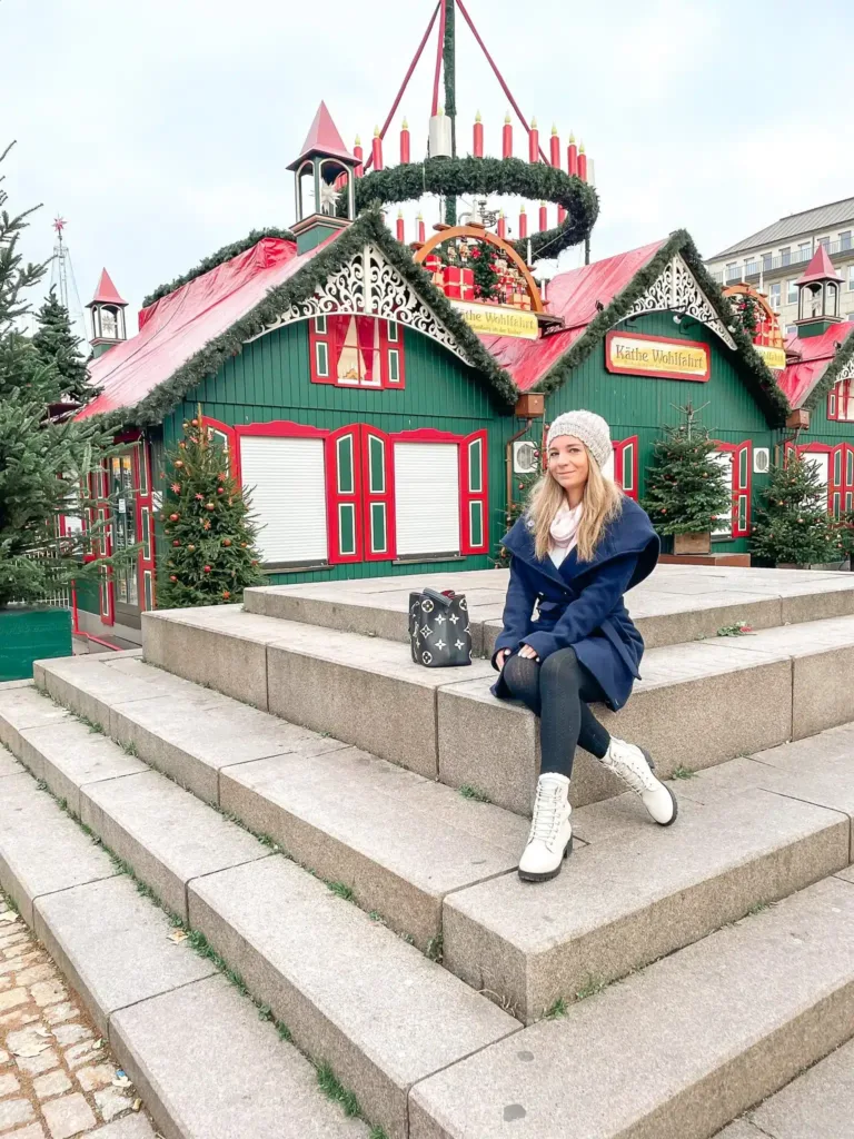 Blonde girl sitting in front of Chalet at hamburg christmas market