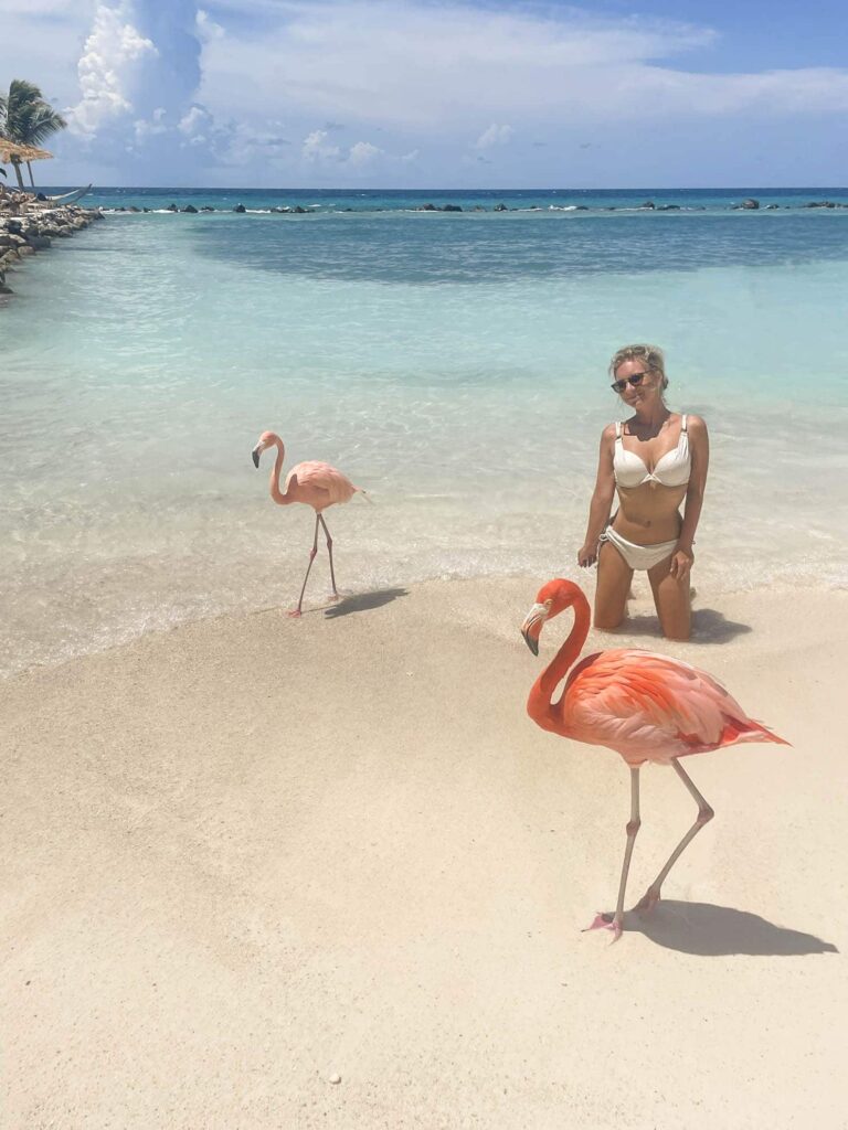Flamingo Beach on Renaissance Island with Blonde girl in swimsuit