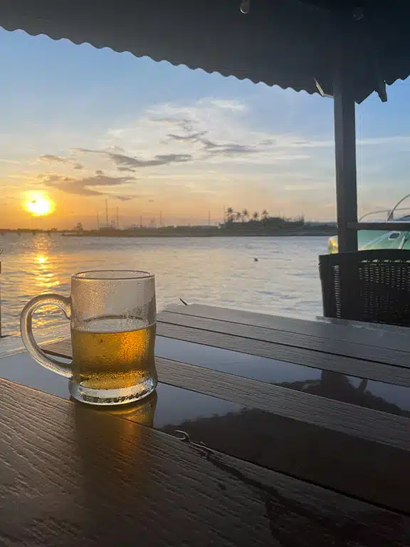 A cold local beer in front of an amazing sunset at the table at Marina Pirata