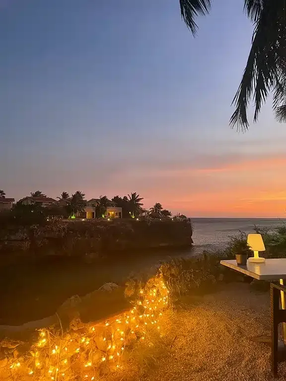Cliff-side outdoor table with sunset view at Playa Lagun