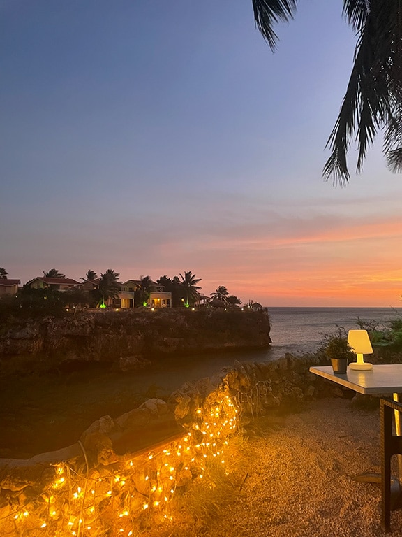 Cliff-side outdoor table with sunset view at Playa Lagun