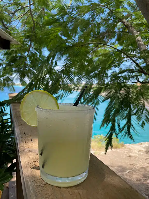 Colourful margarita in front of a bright blue ocean