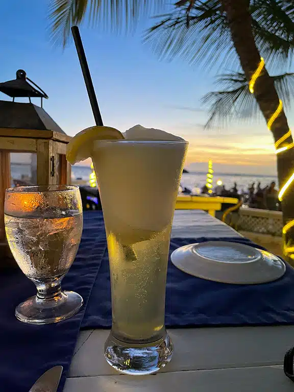 Beer cocktail in front of sunset by the ocean in Aruba