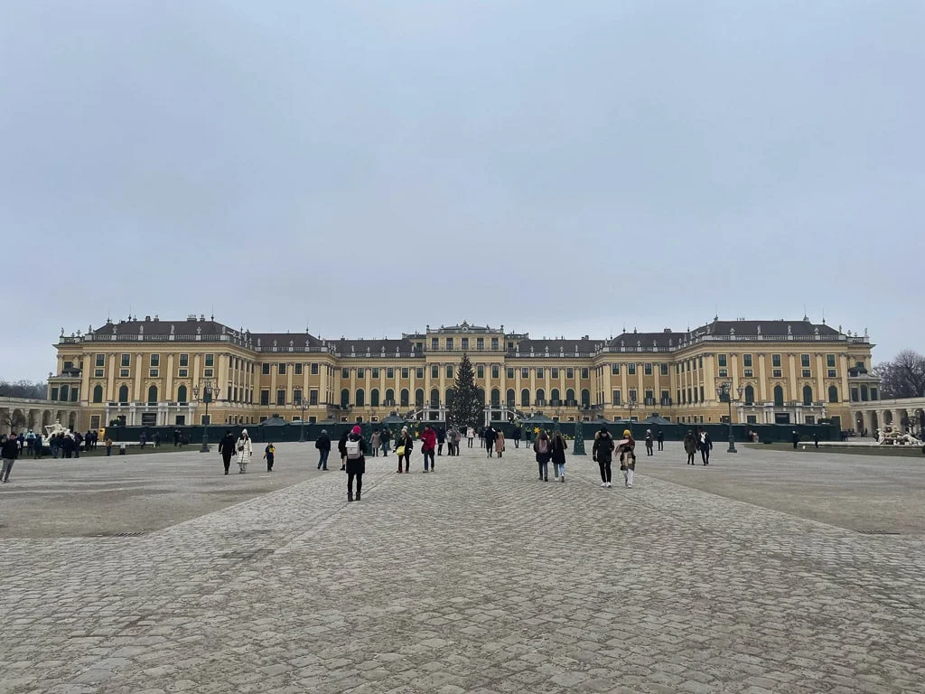 Schönbrunn palaca in vienna in winter with christmas tree, beautiful big castle with small chalets in front of it