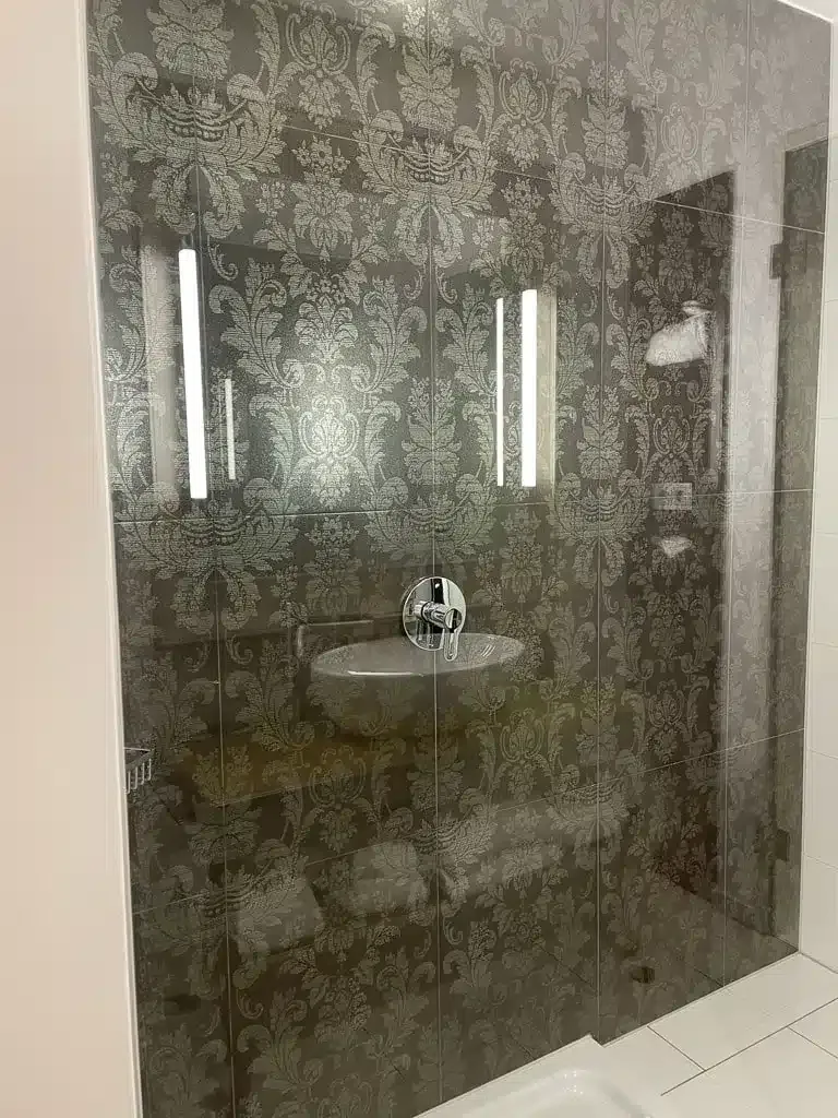 Shower with artful decorated wallpaper in dark grey