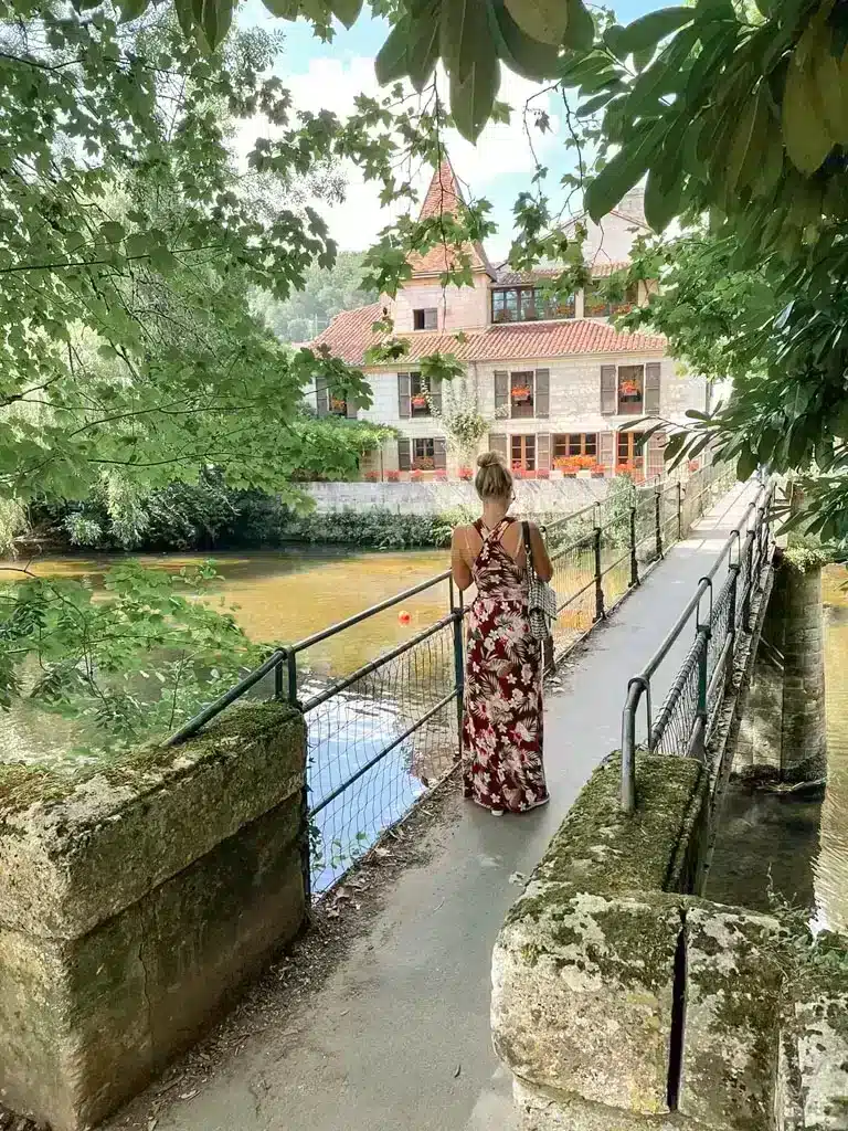 Picture of a girl walking over a bridge in a historical village in the Dordogne called Brantome