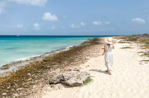 Curacao girl on beach walking in a dress