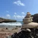 Picture of stones on top of each other and a big bay in the background with crashing waves in Curacao shete boka national park