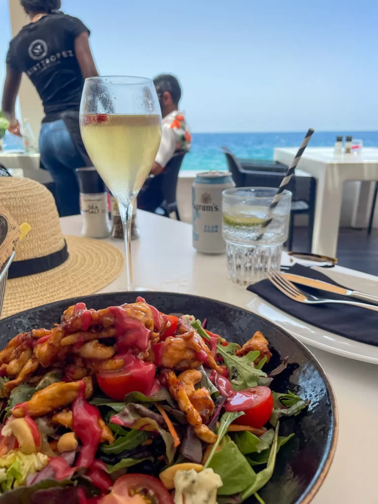 Uitzicht op Caribische Oceaan met een salade en een cocktail