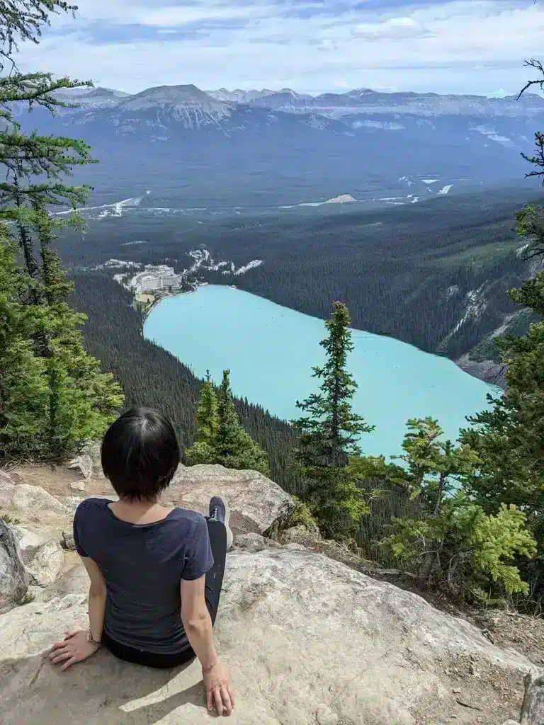 big beehive lake louise girl overlooking lake from above and stunning mountain range in the background USA bucket list adventure
