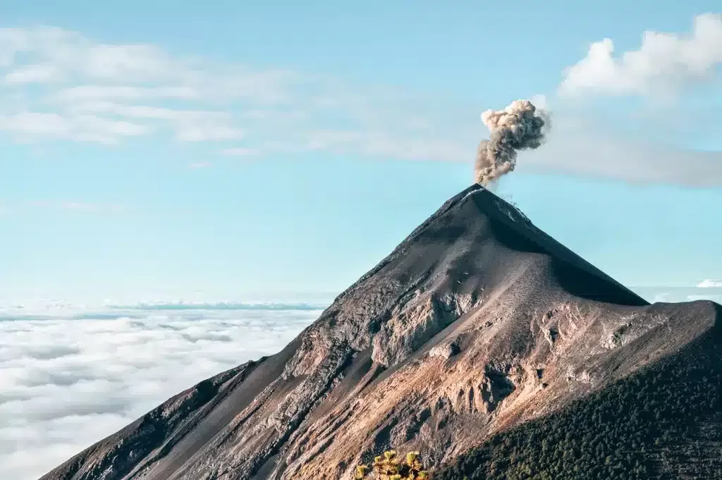 Impressive capture of Acatenango Volcano in Guatemala while it erupts with small cloud on top of it adventure bucket list