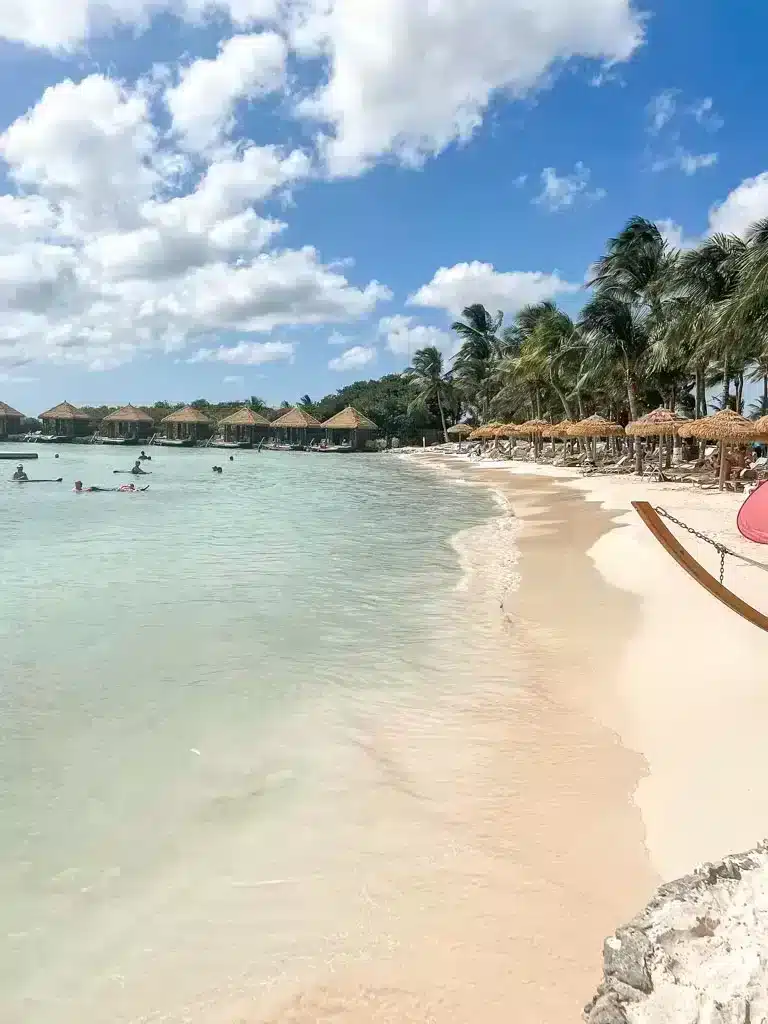 Picture of a beautiful white sandy beach in Aruba with small huts and cabanas in the background