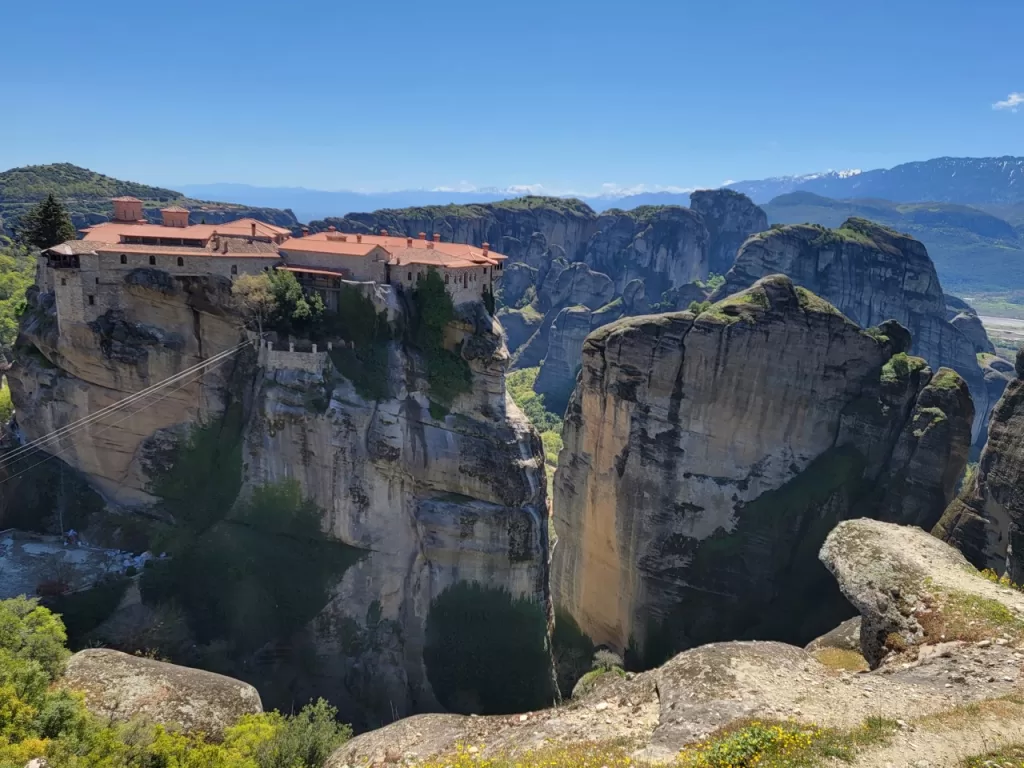 Aerial shot of city Meteora in Greece small houses on a huge cliff 