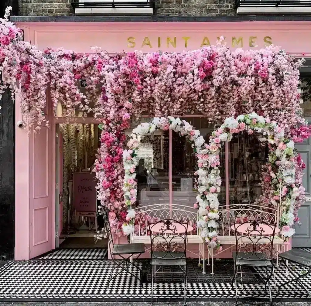 Saint Aymes Cafe in London with colorful instagrammable facade, lots of pink flowers and pink chairs 