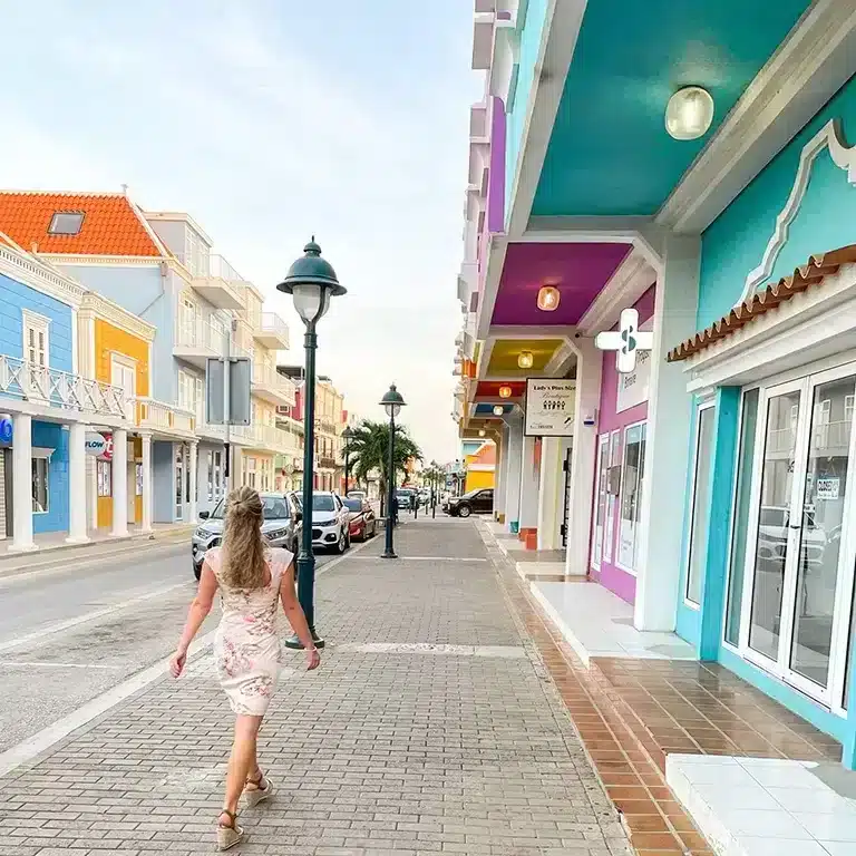 girl walking through colorful street with pastel houses in Kralendijk Bonaire