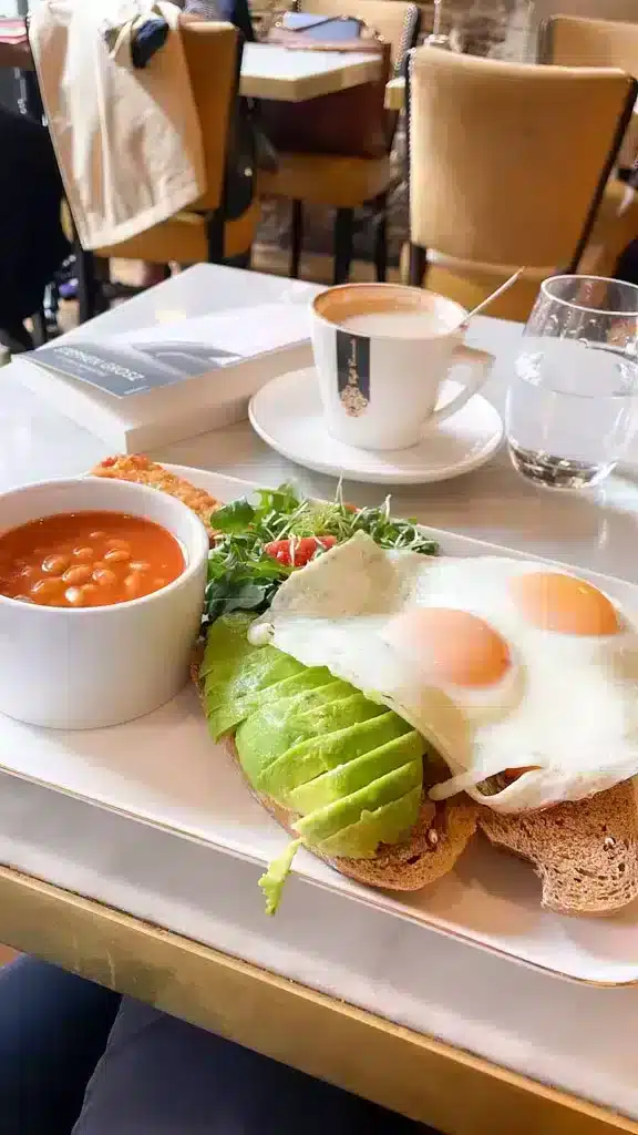 Traditional english breakfast of coffee, baked beans and avocado bread