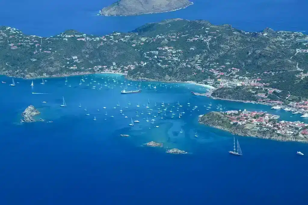 Drone shot of St Kitts Caribbean island with lots of boats in harbor and blue water 