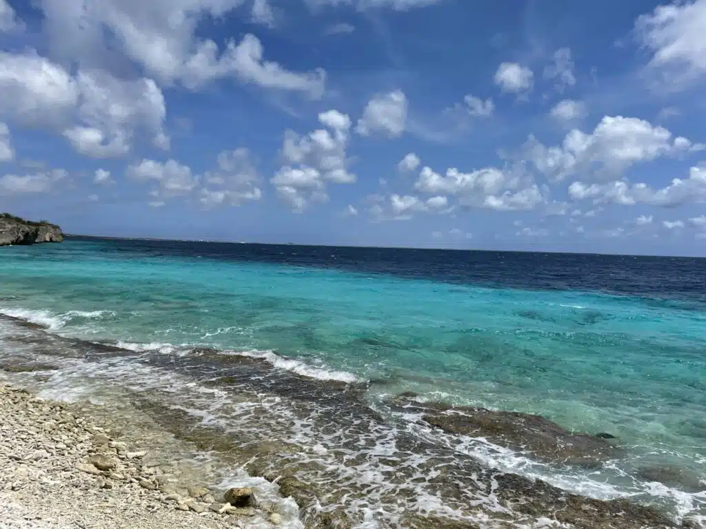 Prachtige blauwe oceaan op rotsachtig strand in Bonaire een van de beste bezienswaardigheden op Bonaire