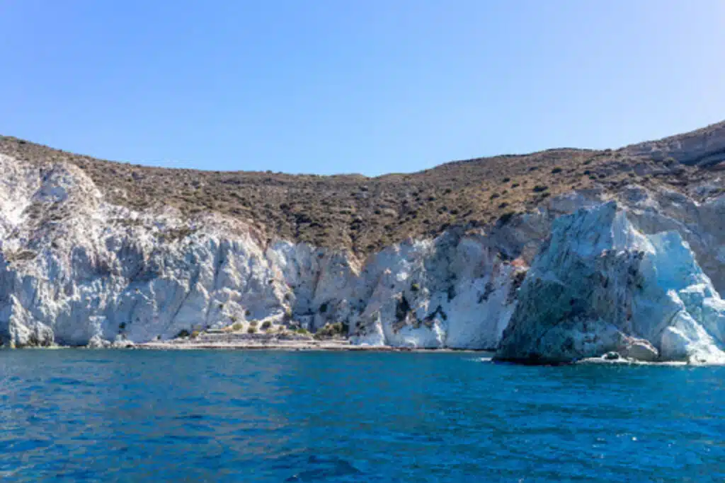 picture of impressive white cliffs in santorini taken from a boat, white beach santorini