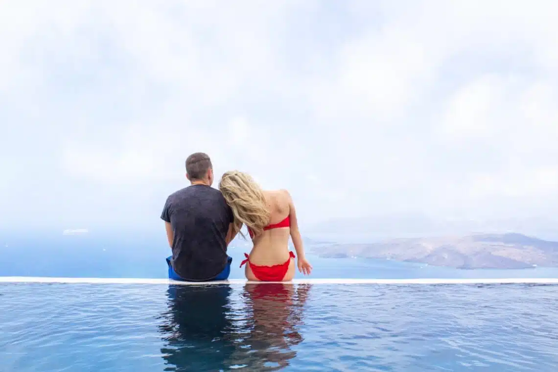 author and her husband on boutique luxury hotel infinity pool santorini