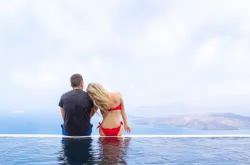 author and her husband on boutique luxury hotel infinity pool santorini