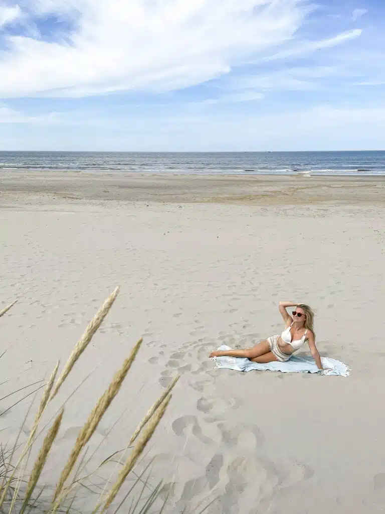 beach of Ameland with a picture of the Author lying on a blanket