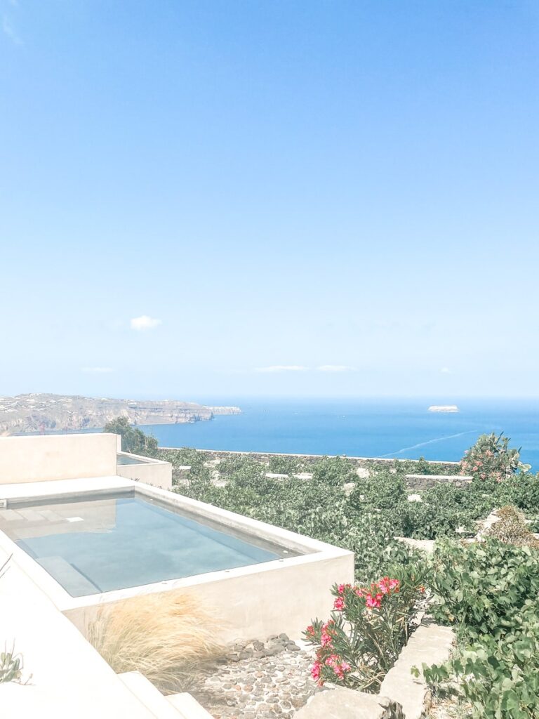 Smaller suite of the Azanti Suites Santorini with pool overlooking vineyards and ocean