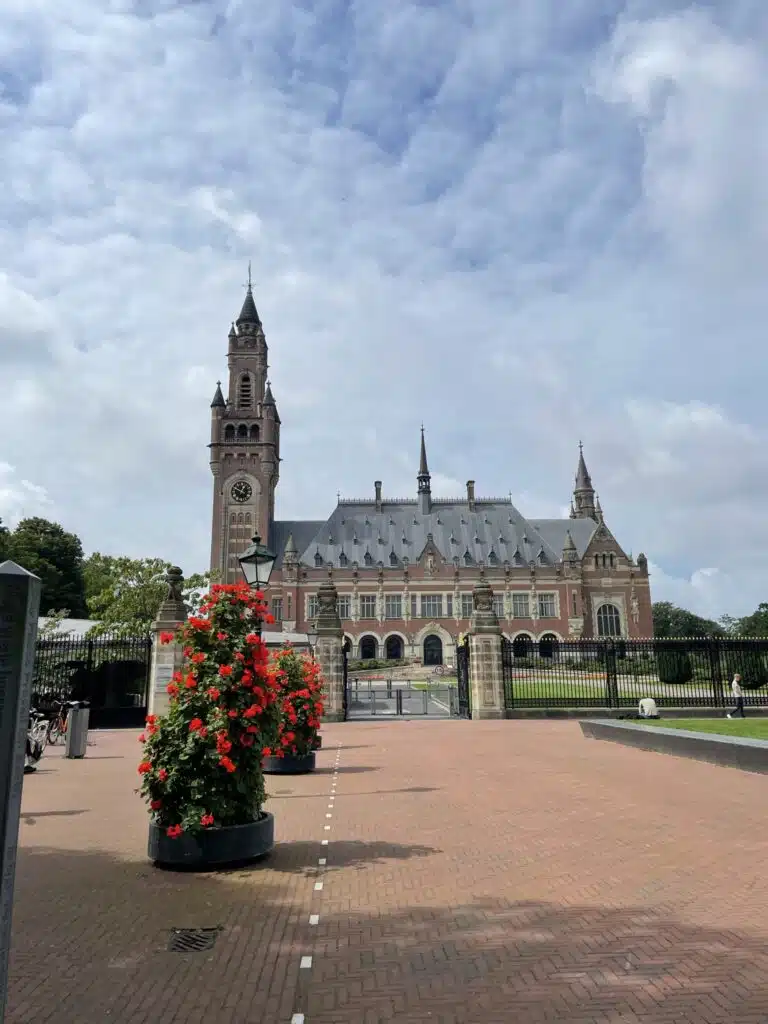 the peace palace in the hague with some flowers in front