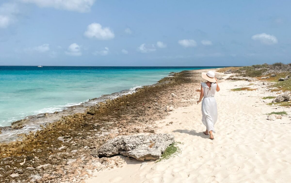 author on klein curacao beach walking in a sundress on white sandy beach, day trip that needs to be on everyone's curacao itinerary