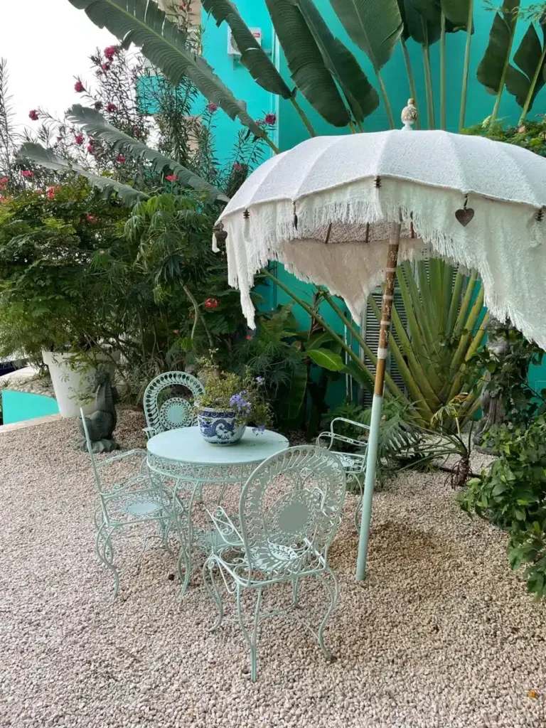 cute little umbrella and table with chairs outside near a pool in bonaire