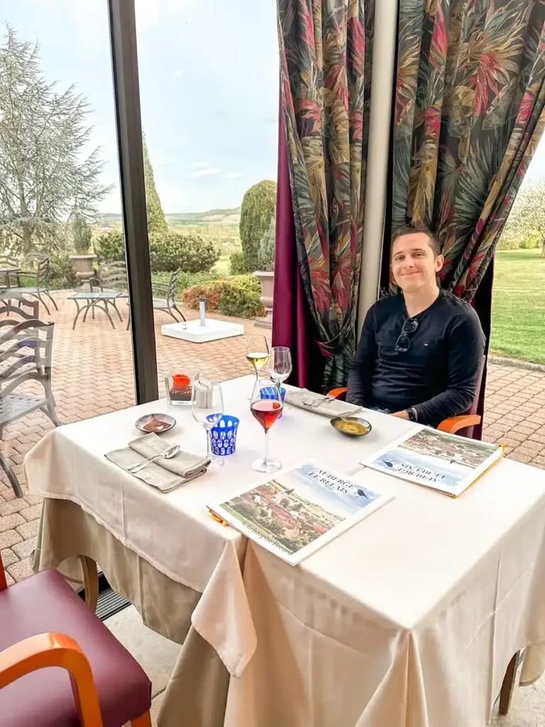 echtgenoot van de auteur zittend aan een mooie restauranttafel in frankrijk