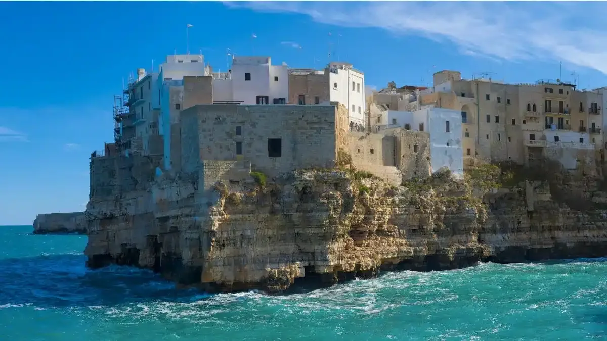 beautiful bari in front of blue water and white washed houses on cliffs perched