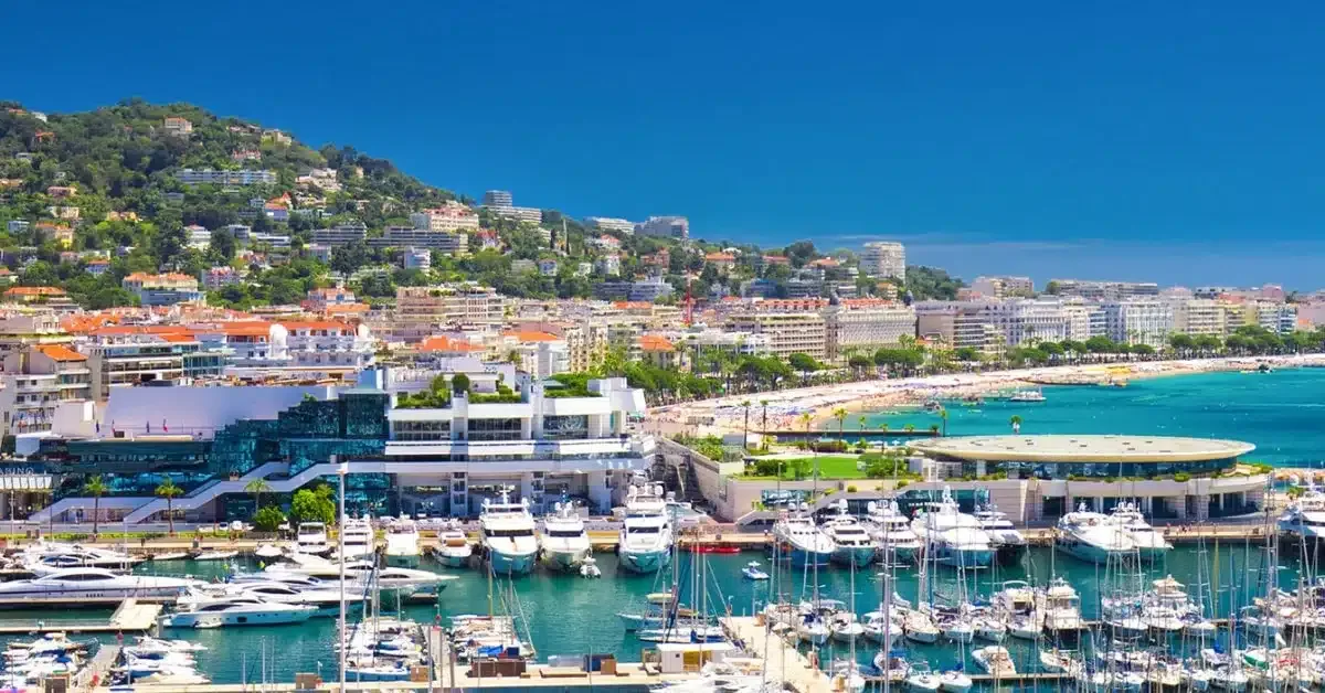 aereal shot of cannes with beautiful small harbor and fishing boats and old town in the background