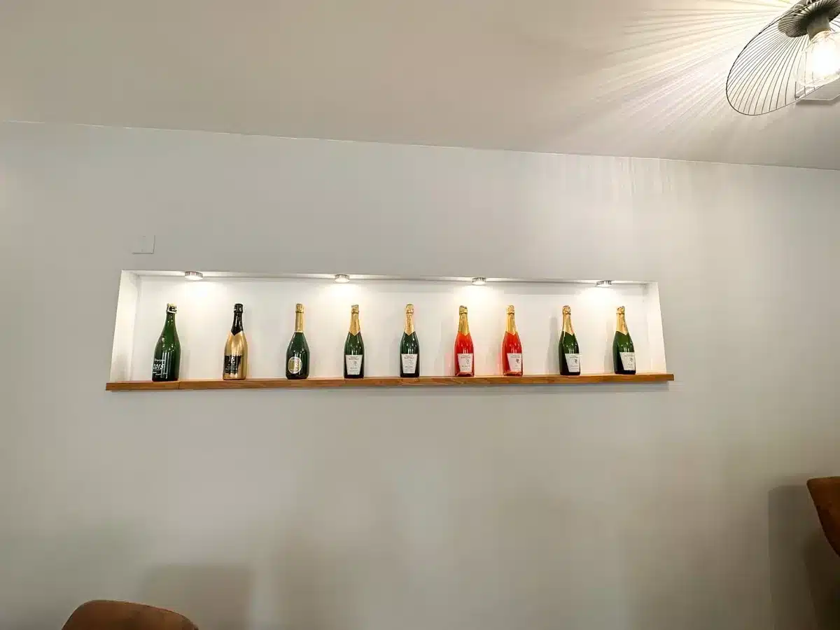 10 different champagne bottles on a wall next to each other