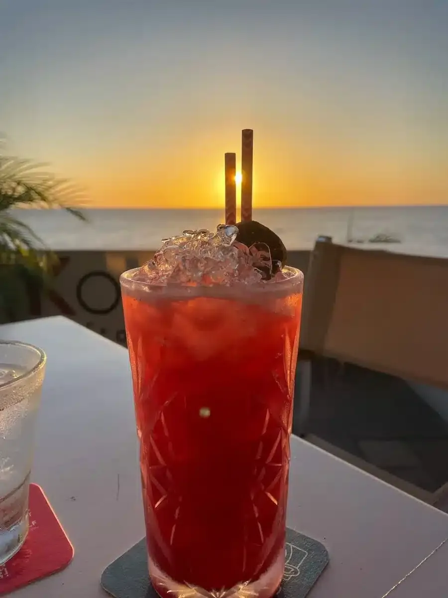 cocktail over sunset at koraal rooftop