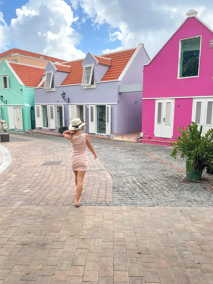 the author walking next to colorful houses in willemstad otrobanda 