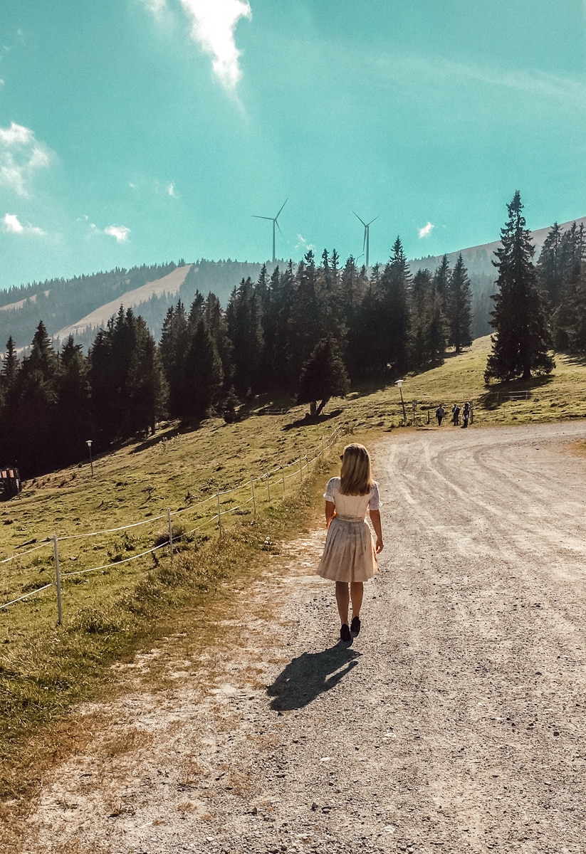 the author walking on a mountain in a traditional styrian dirndl 