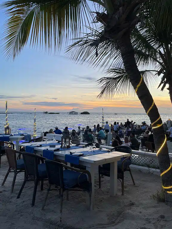 flying fishbone restaurant with tables in the water at sunset