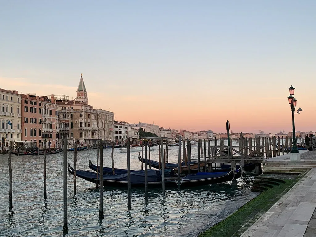 venice in the evening with gondolas as the sun sets behind