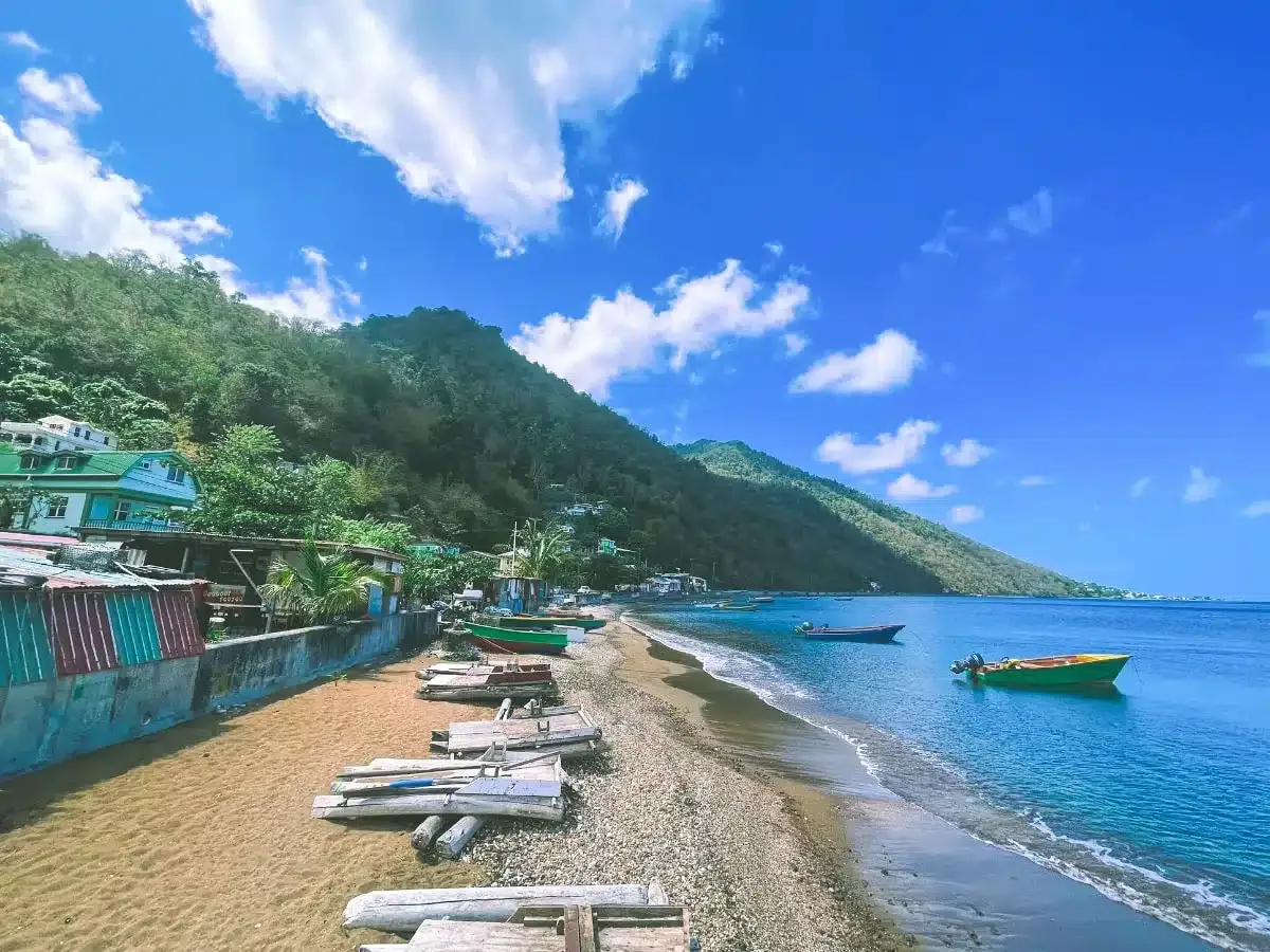 beautiful beach with rainforest and fisher boats in dominica in december