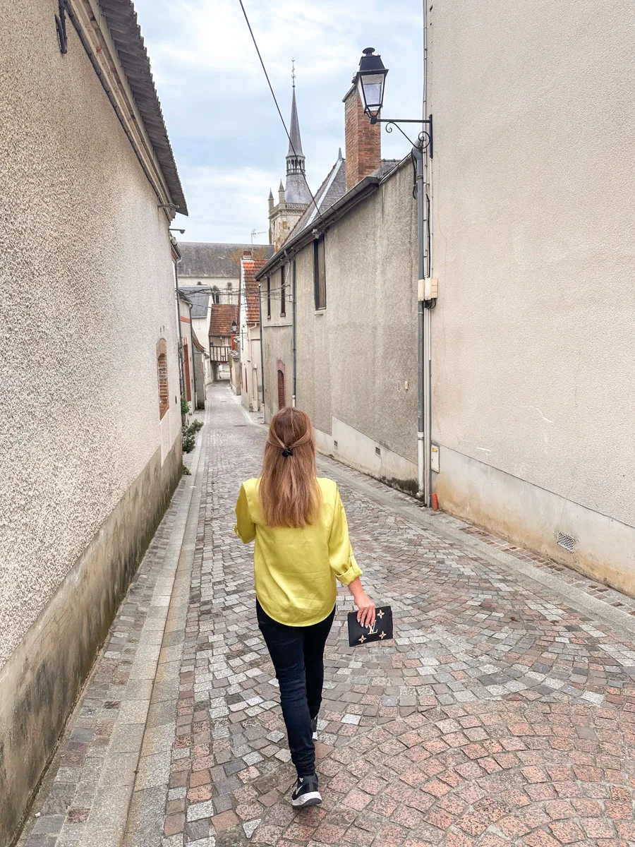 the author in ay de champagne walking down a small alley
