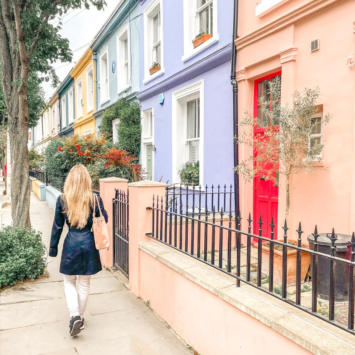 the author walking next to a row of colorful houses