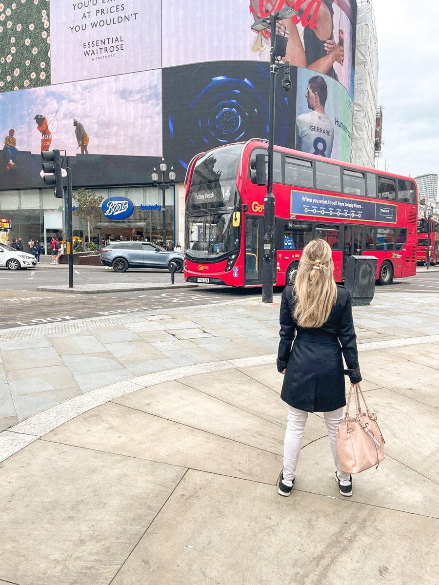 the author standing on piccadilly circus checking out a big red bus and the led sign