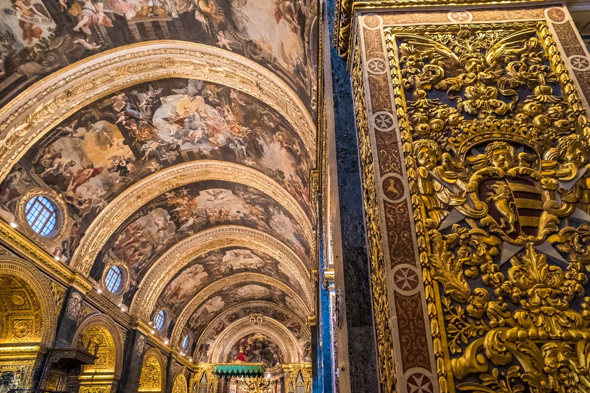 inside decorations of the st johns co-cathedral with beautiful gold ornaments and paintings on the ceiling