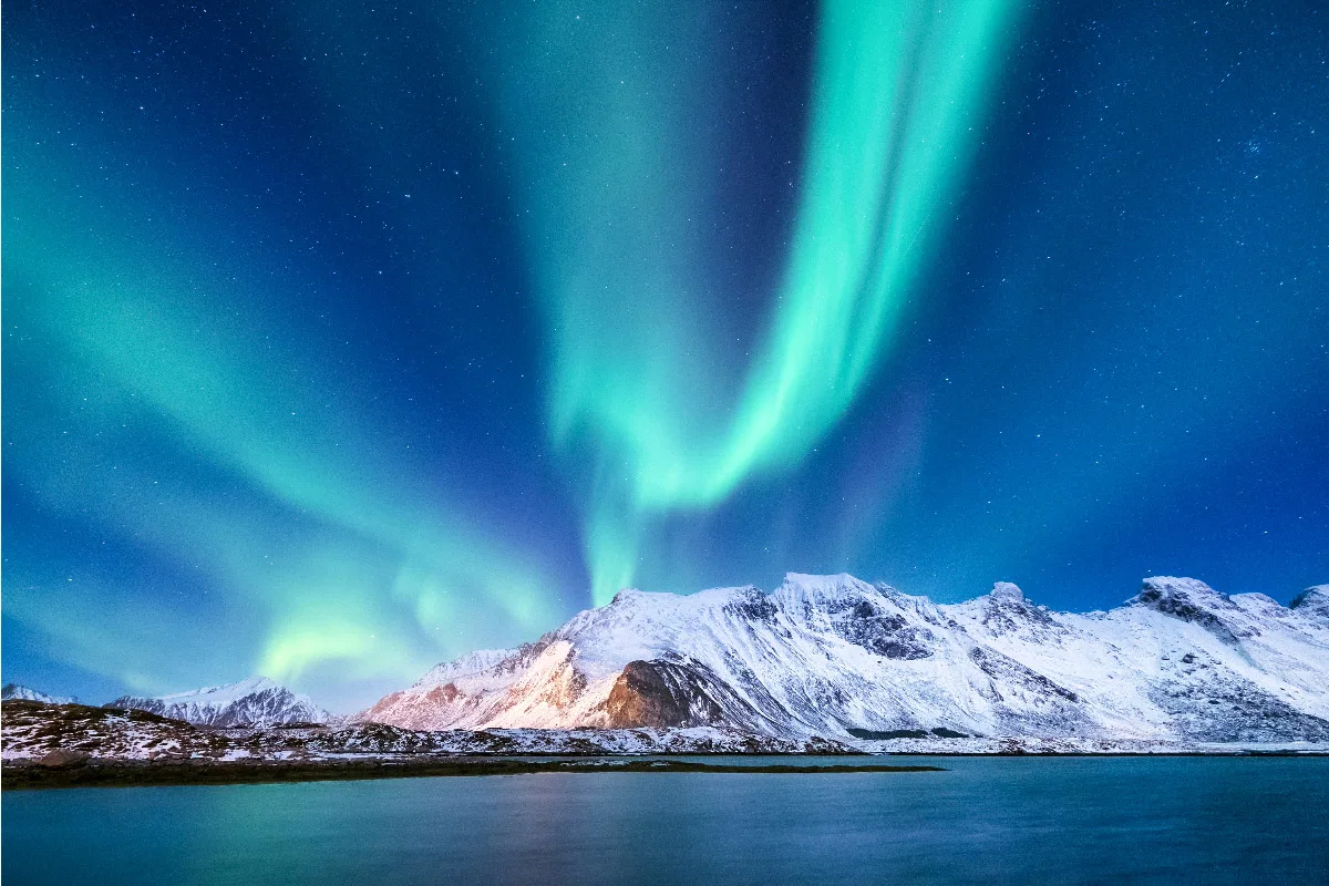 stunning northern lights over alaska on a like and some glacier in the foreground