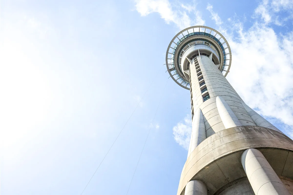 picture of the sky tower from auckland from below in front of clear blue sky