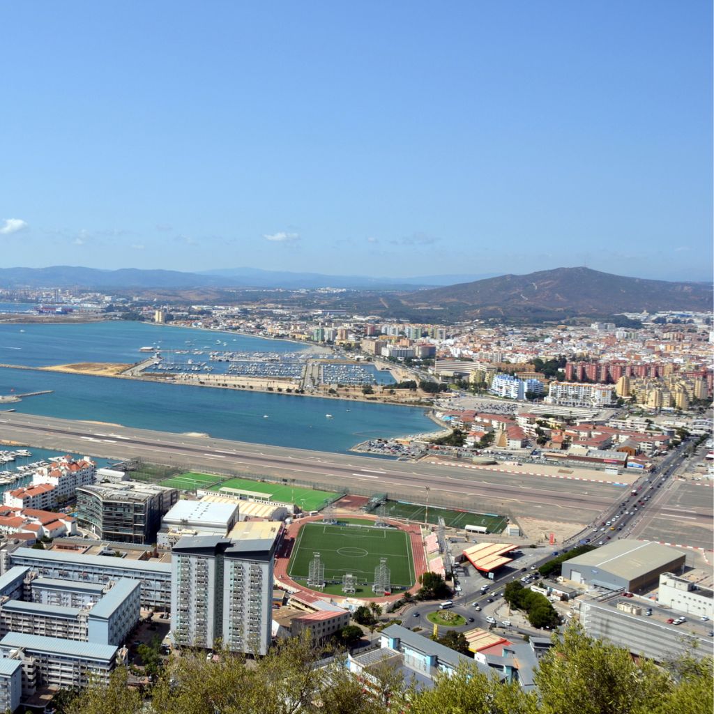 aerial shot of the landing strip in gibraltar that is crossing with a normal street