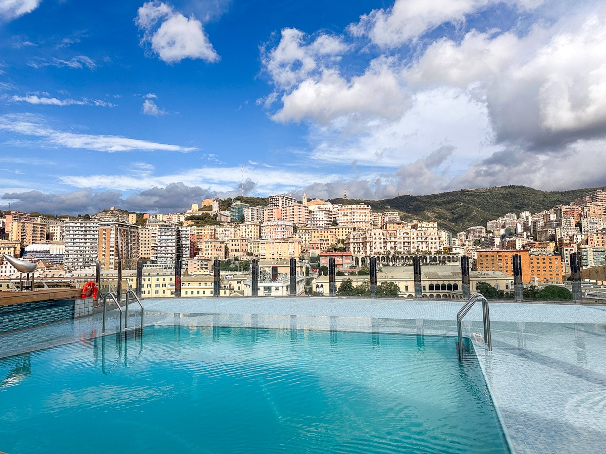 stunning infinity pool on a big cruise ship from msc cruises in front of genoa houses on a hill